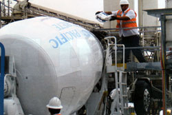A worker easily adds KIM admixture to a cement truck, saving time compared to typical membrane application procedures.