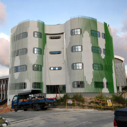 The new building for the health sciences institute of Universiti Brunei Darussalam stands tall against a bright blue sky.