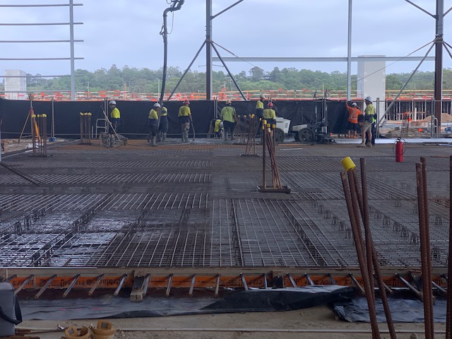 Construction workers are working on setting up a worksite and shotcrete for the construction of Woolworths' Moorebank distribution centers.
